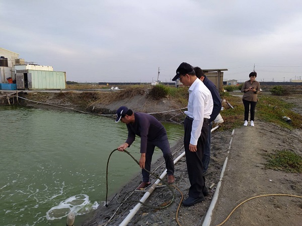 漁民使用鼓風機產生熱氣注入魚塭(左1漁民、左2海洋局黃登福代理局長)